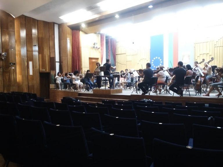 Orquesta sinfónica en ensayo en un auditorio